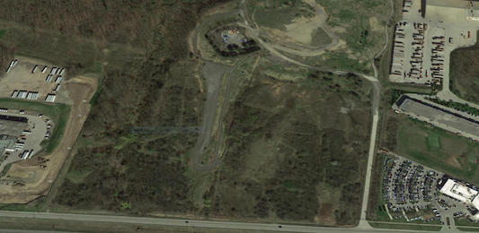 A satellite image of an airport runway and a building.